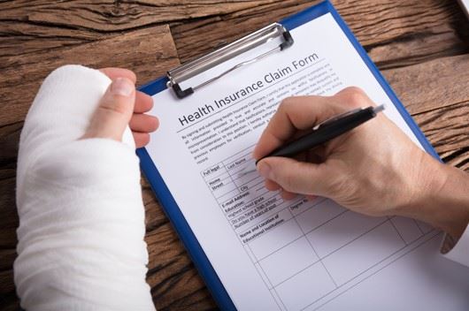 man with work injury filling out health insurance claim form