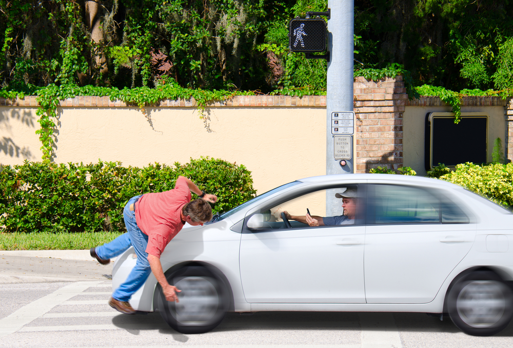 A man that is texting while driving runs over a pedestrian